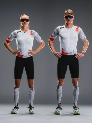 Två idrottare i cykelkläder, stående med händerna på höfterna, poserar i studio.